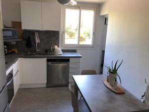 a small kitchen with a table and a window at Chambre avec salle d'eau privée dans appartement partagé 200 m du tram in Montpellier