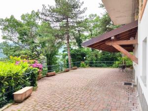 a brick patio with a wooden awning and flowers at Bellavista Iseo in Villongo SantʼAlessandro