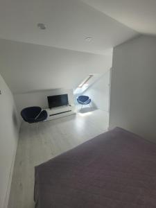 a white room with a bed and two chairs at Apartamenty Platinum 2 in Łukęcin