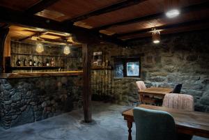 a stone room with a wooden table and chairs at Edis Dacha in Tsalka