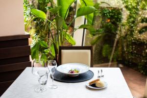 a table with a plate of food and wine glasses at Zen Hotel Versilia in Marina di Pietrasanta