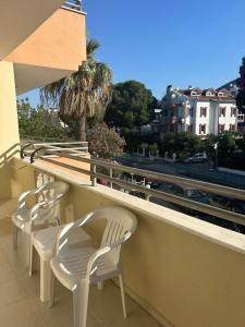 a balcony with white chairs and a view of a city at Family Apart in Marmaris