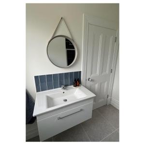 uma casa de banho com um lavatório branco e um espelho. em Eastbury House em Cork