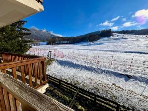 a snow covered field with a fence in front of it at Studio 27m2 in Ancelle