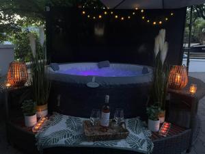a hot tub with a table with wine glasses and lights at Luxury House Cesarica in Cesarica