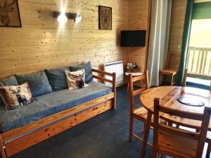 a living room with a couch and a table at Studio 27m2 in Ancelle