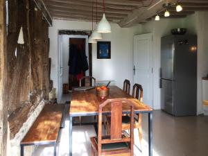 a dining room with a table and chairs and a refrigerator at L'oisellerie Cottages in Le Renouard +17 photos
