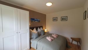 a bedroom with a bed with pink pillows on it at Ruhe & Entspannung an der Ostsee - Ferienbungalow Baumann in Graal-Müritz in Graal-Müritz