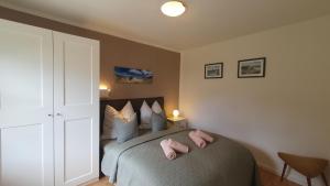 a bedroom with a bed with pink slippers on it at Ruhe & Entspannung an der Ostsee - Ferienbungalow Baumann in Graal-Müritz in Graal-Müritz +24 photos