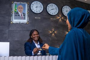 FASQ Hotel في نواكشوط: امرأة تقف امام مرأة امام الساعة