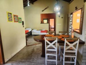 Un comedor con mesa y sillas de madera. en Vila Feliz Arraial, en Arraial d'Ajuda