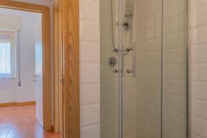 a shower with a glass door in a bathroom at Argentario Retreat Sea View Terrace, WiFi & Private Parking Included in Porto Santo Stefano +13 photos