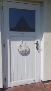 a white garage door with a surfboard on it at Ruhe & Entspannung an der Ostsee - Ferienbungalow Baumann in Graal-Müritz in Graal-Müritz