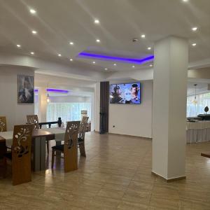 a dining room with a table and a tv on a wall at Brilliance in Varna City