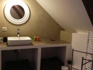 a bathroom with a sink and a mirror at L'oisellerie Cottages in Le Renouard