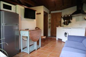 a kitchen with a refrigerator and a table and a microwave at Casa Chidro in Buesa