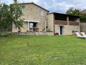 a stone house with a table and chairs in a yard at Villino Giulio in Duddova