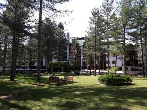 a park with benches and trees in front of a building at Casa StePa in Pescasseroli