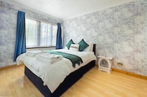 a bedroom with a large bed with blue curtains at Morden holiday in Basildon