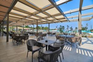 an outdoor patio with tables and chairs and a pool at Mobile Homes Relax Park Umag in Umag