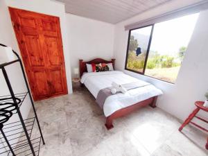 a bedroom with a bed and a large window at Hermosa Casa en Medio de la Naturaleza Monteverde in Monteverde Costa Rica