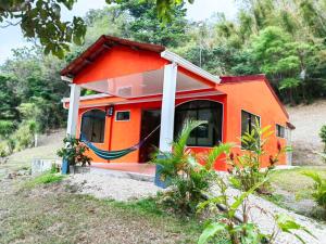 a small orange house on the side of a hill at Hermosa Casa en Medio de la Naturaleza Monteverde in Monteverde Costa Rica