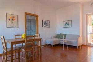 a living room with a table and a couch at Argentario Retreat Sea View Terrace, WiFi & Private Parking Included in Porto Santo Stefano