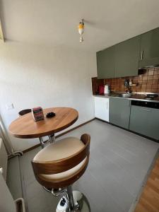 eine kleine Küche mit einem Holztisch und einem Stuhl in der Unterkunft Cooles Apart an der Kathedrale in Freiburg im Üechtland + 9 Fotos
