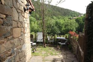 a stone wall with a table and chairs in a yard at Casa Chidro in Buesa +16 photos