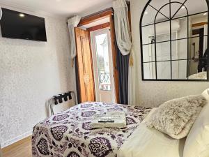a bedroom with a bed and a mirror and a window at Charme da Graça - Guest House in Lisbon