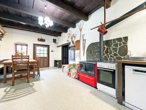 a kitchen with a red stove and a table at Modrá chalupa in Pliešovce