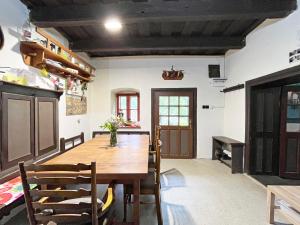 a dining room with a wooden table and chairs at Modrá chalupa in Pliešovce