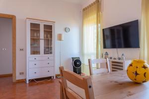 a living room with a table and a tv at Argentario Retreat Sea View Terrace, WiFi & Private Parking Included in Porto Santo Stefano