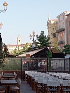 a restaurant with wooden tables and white chairs at Le Fontana in Nice