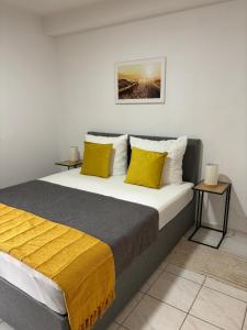 a bedroom with a large bed with yellow pillows at Apartmani Ivanic in Vir