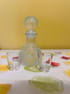 a table with two glasses and a bottle on it at Pink House 2 in Palaiochora +16 photos