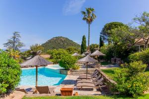 a pool with chairs and umbrellas in a resort at Résidence Les Toits de Santa Giulia in Porto-Vecchio