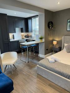 a bedroom with a bed and a kitchen with a table at Peaceful & Stylish Brighton Studio Apartment in Brighton & Hove