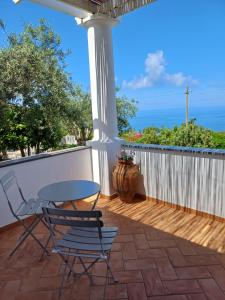 a patio with a table and chairs on a deck at La Casa di Pitti in Anacapri