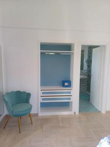 a room with a blue chair and a closet at La Casa di Pitti in Anacapri