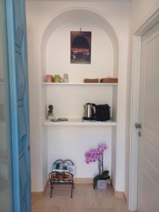 a hallway with white shelves and a vase of flowers at La Casa di Pitti in Anacapri