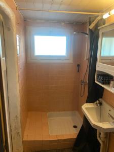 La salle de bains est pourvue d'une douche, d'une fenêtre et d'un lavabo. dans l'établissement Chambre double 10 min du circuit, à Allonnes 13 autres photos