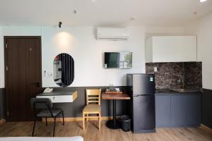 a kitchen with a refrigerator and a table and chairs at Ruby Star Hotel Nam Quoc Cang in Ho Chi Minh City