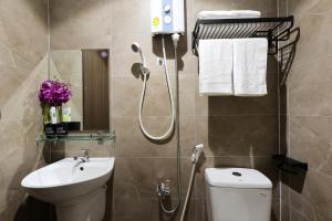 a bathroom with a shower and a toilet and a sink at Ruby Star Hotel Nam Quoc Cang in Ho Chi Minh City +30 photos