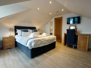 a bedroom with a bed with a tv on the wall at Meadow View Apartments in Newquay