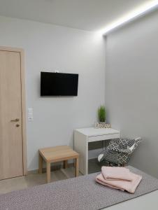 Zimmer mit einem TV, einem Stuhl und einem Tisch in der Unterkunft Black Eagle Apartment in Drama