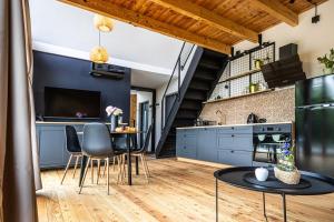 a kitchen with blue cabinets and a table with chairs at Między Olchami 2 in Barczewo
