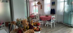 a dining room with a table and chairs with fruits and vegetables at Tina Guest House in Basarabi
