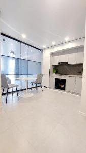 a large white kitchen with a table and chairs at Новобудова вулиця Стрийська 45а FABRIK in Lviv