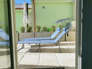 a blue bench on the side of a house at Sun and Sand Focene in Focene +14 photos